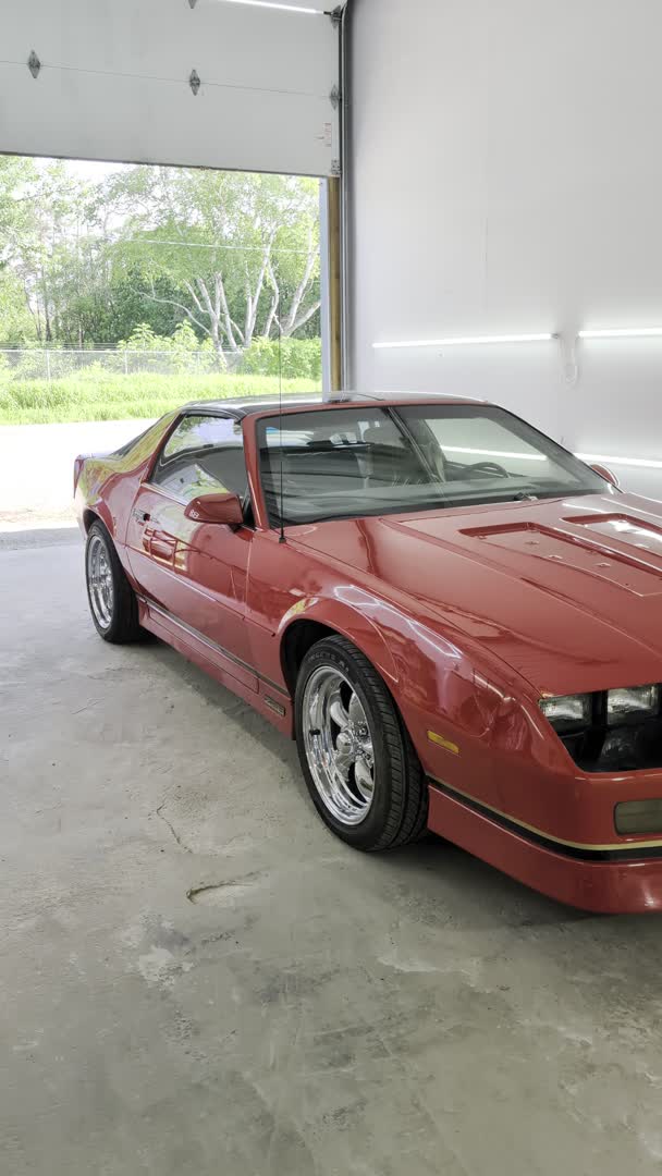 A freshly reconditioned red Camaro with a deep gloss finish in The Hive's shop